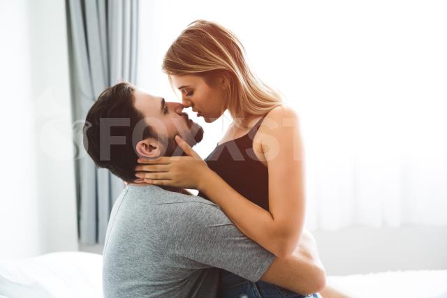 Casal relaxado se beijando na cama | Stock Photos