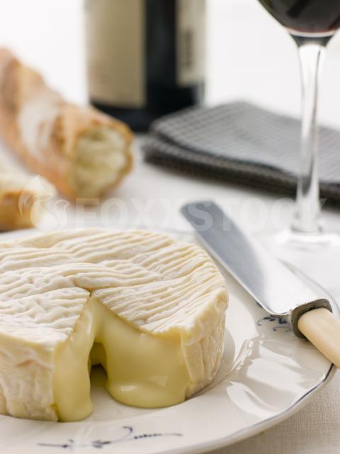 Round of camembert cheese with French stick and Red Wine