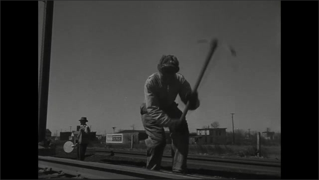 1940s: Long shot, line of people in cotton field, people bend down, pick cotton. Shots of men working on railroad tracks.  