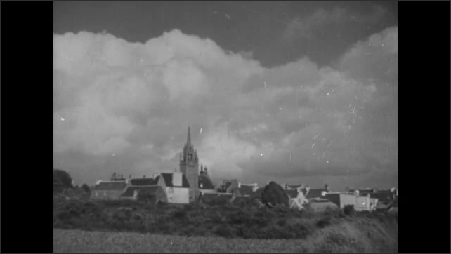 1940s: Religious statue.  Clouds.  Small town.