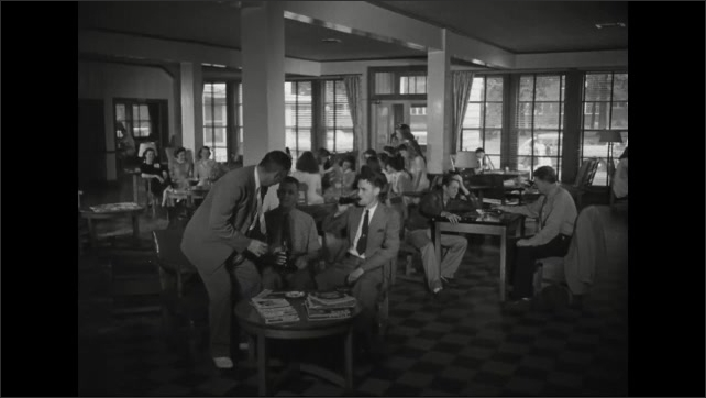 1940s: People seated around open room at different tables, talking, doing activities. Three men enter room, talking, drinking from glass bottles, sit at couch.