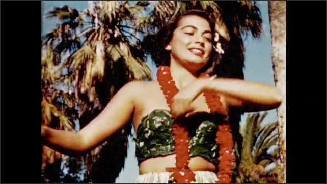1950s: Medium shot of woman dancing Hula. Two women dance Hula outdoors with band.