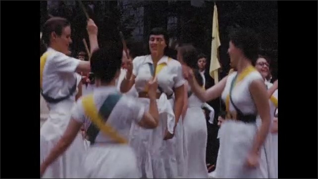 1950s: Smiling Bryn Mawr students pose for camera; young women perform traditional dance with sticks; young woman conducts large group singing in front of crowds.