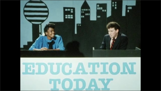 1980s: A black teenage boy speaks in front of a painting. Girl looks at painting. Two teen newscasters speak from behind a desk - girl gestures to painted cityscape. Young man stands in busy office.