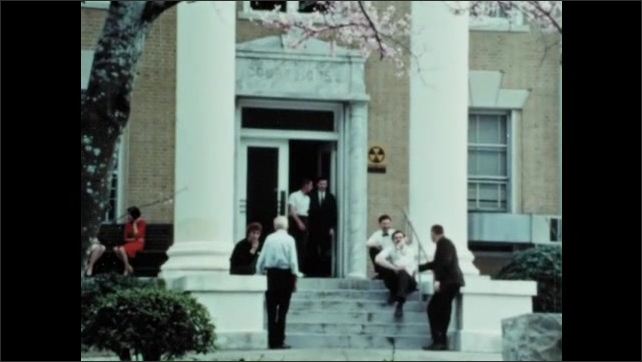 1960s: Bell outside Supreme Court building in Florida. Spring blossom outside building. Men shake hands. Men thank Gideon. 