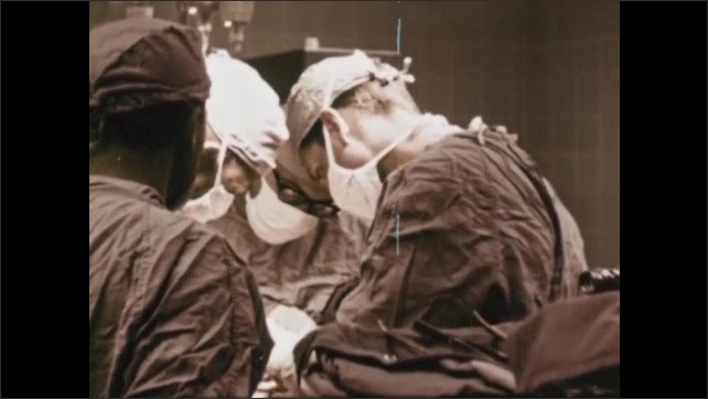 1960s: new artificial heart valve in place. Surgeon starts heart after valve replacement. Surgeons in cardiac theatre. Heart and lung bypass machine. 