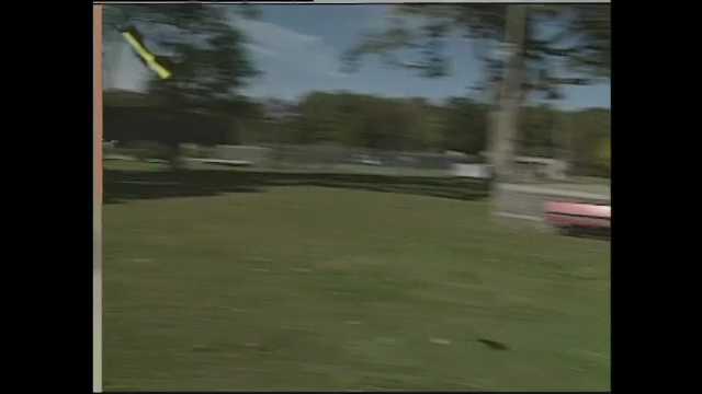 1990s: Nerf toy planes float and crash on lawn in park. Men toss Nerf toy gliders in park.