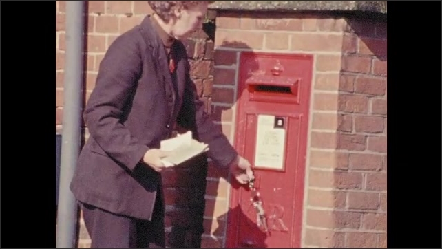 England 1970s: Woman exits postal delivery vehicle. She opens a postbox and collects mail. Boy in school uniform runs. Train speeds through a station. Boy watches from gate. Person cranks a wheel.