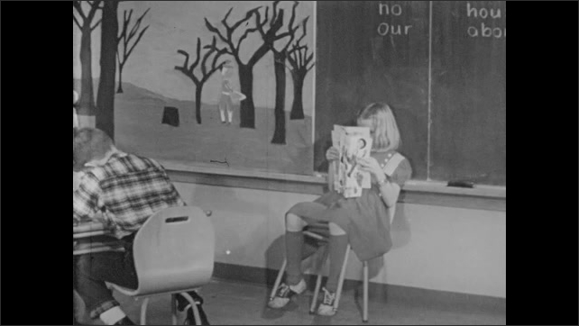 1950s: Children at their desks. Safety guide watching. Girl with magazine leaning in her chair.