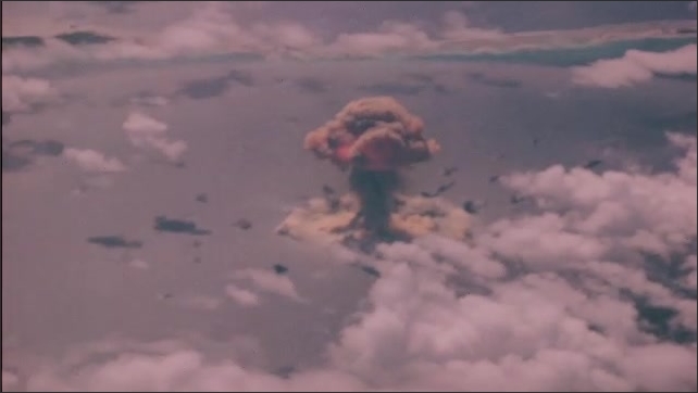 1940s Bikini Atoll: atomic bomb detonation test, with condensation rings. Mushroom cloud and central column of smoke.