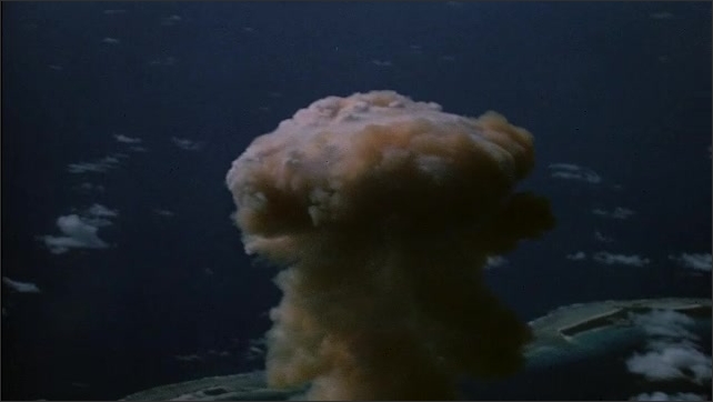 1940s Bikini Atoll: mushroom cloud and central column of smoke from atomic bomb detonation test.