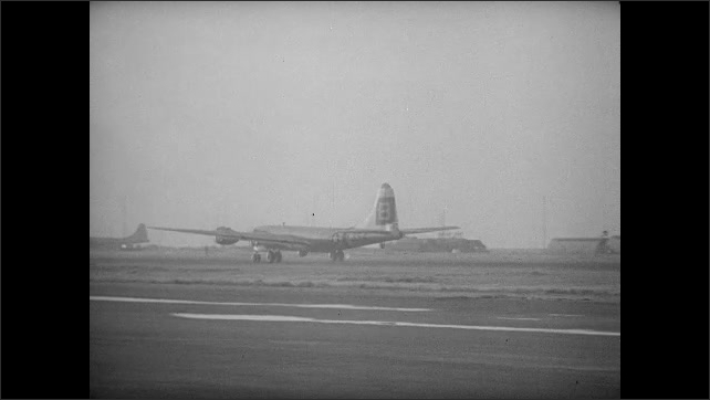 1940s Bikini Atoll: B-29 Bomber lands on runway. B-29 Bomber plane takes off from runway at air base.