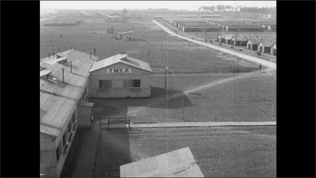 1910s France: Building marked "YMCA."  Dirt road.  Barracks.