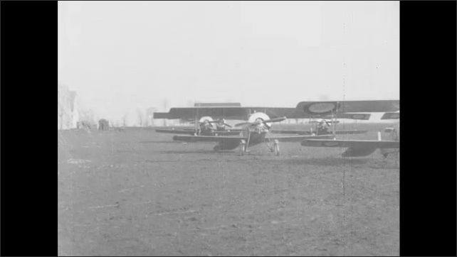 1910s France: Airplanes parked in field.  Temporary buildings.