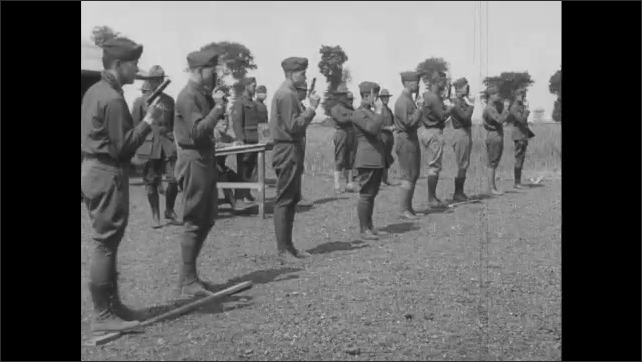 1910s France: Line of soldiers practicing aiming and shooting guns at firing range.