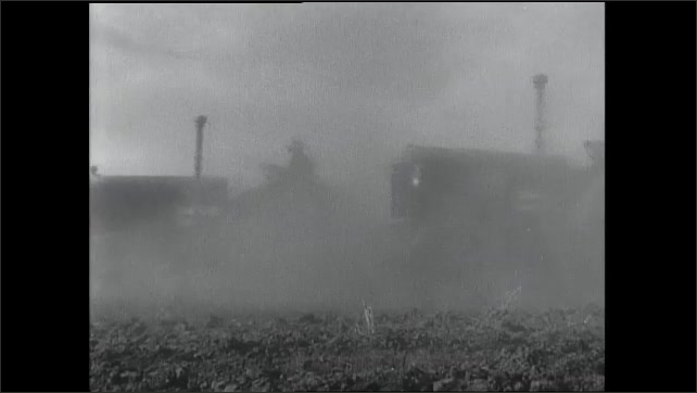 1930s: Fleet of tractors drive across field of dirt.