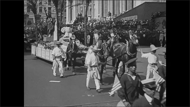1910s: Float in parade. Parade in street. People and floats in parade.