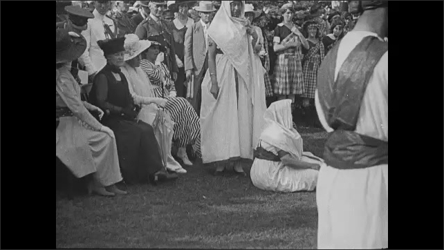 1910s: Two men and two women dance together in circle as people watch. Crowd. People dancing.