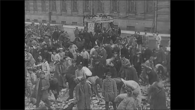 1910s Russia: Soldiers marching. Men pulling on slabs of of concrete and wire. Crowds sorting through rubble at a port. Lenin watches ragtag group of soliders march. 