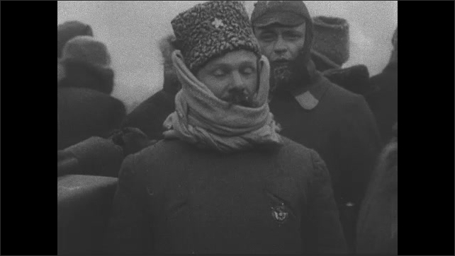 1910s USSR: Mourners file past flag draped coffin of Lenin. Mourners and soldiers stand outside in the Red Square in winter cold with frosted beards and mustaches. 