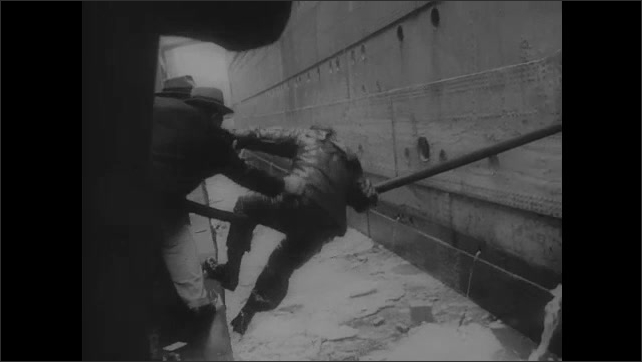 1940s: Crowd cheers as ship docks.  Men help soldier cross ropes to get to shore.  Soldiers carry luggage off ship.  Soldiers give bottles to babies.