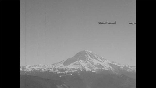 1940s: Planes fly over mountains.  Caption reads "SEATTLE, WASH."  