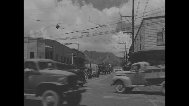 1941 Pearl Harbor: Traffic driving through intersection, tank drives past.