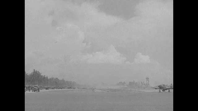 1940s Pacific Islands: Propellor planes taxis on tropical island and joins long line of other planes.