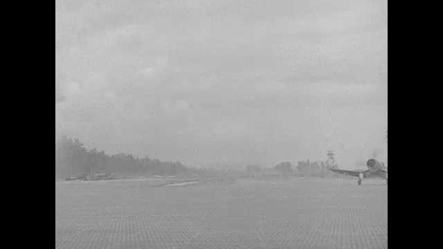 1940s Pacific Islands: Propellor planes lands and taxis on makeshift runway.