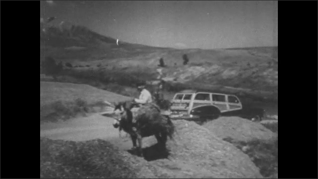 1950s Greece: Car drives along mountain road.  Gated compound.  Man on horse.  Men work moving rocks.  Ruins of building.