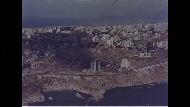1960s: Aerial view of city with helicopter flying overhead.
