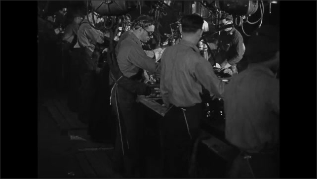1940s: Car door rolls down assembly line, men work on doors as the come down line.