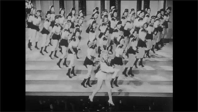 1940s: Stage.  Betty Grable dances in front of backup dancers.