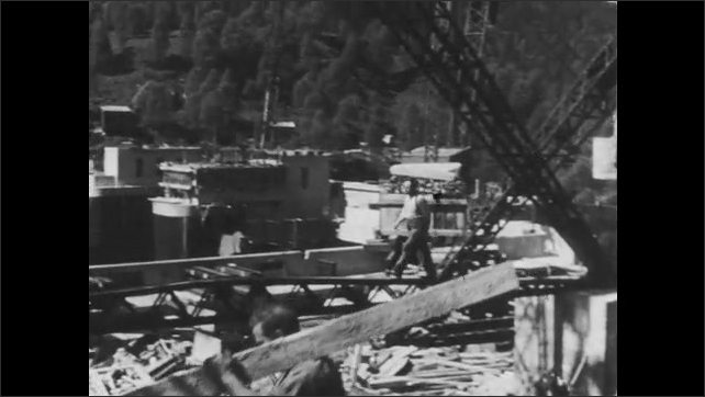 1940s Britain: Supplies moved by crane to bridge under construction.