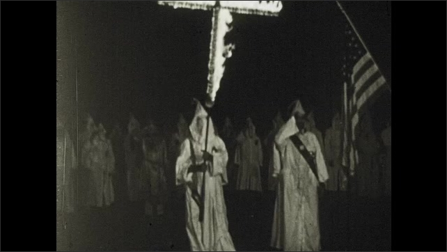 1910s: Montage of events leading to WWI. KKK members burn cross and hold meeting in field.