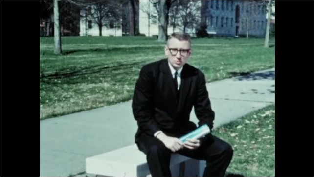 1960s: Bruce Jacob talks to camera about Gideon case. Man sits on bench and speaks to camera. Man in black suit and glasses. Man holds magazine in hand. 