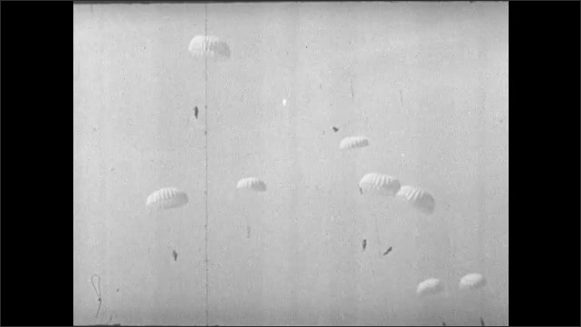 1930s: Aerial shot, paratroopers jumping from planes. Close ups, soldiers jumping out of plane. Paratroopers falling. Aerial shots, paratroopers dropping. 