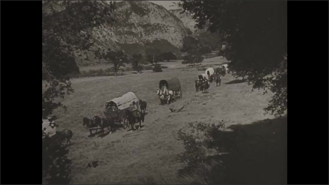 1930s: New York City. A skyscraper. People in covered wagons and on horse back cross a desert. Man gives a boy a scythe outside a house. Steam locomotives meet on a track.
