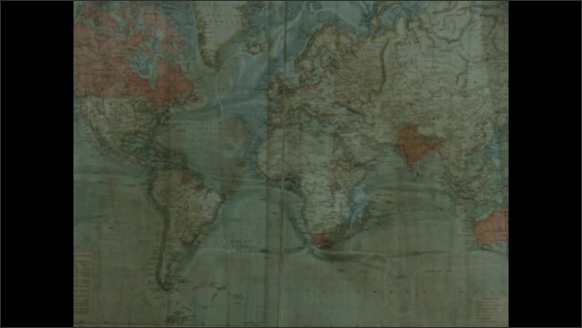 1880s: Men look at map, gesture, and speak. Map of the world.