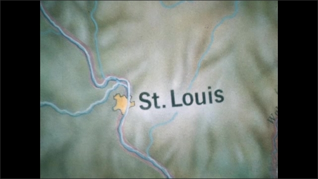 1800s: Looking across map of United States to St. Louis. Person with film slate. Person points to area in Midwest on map.