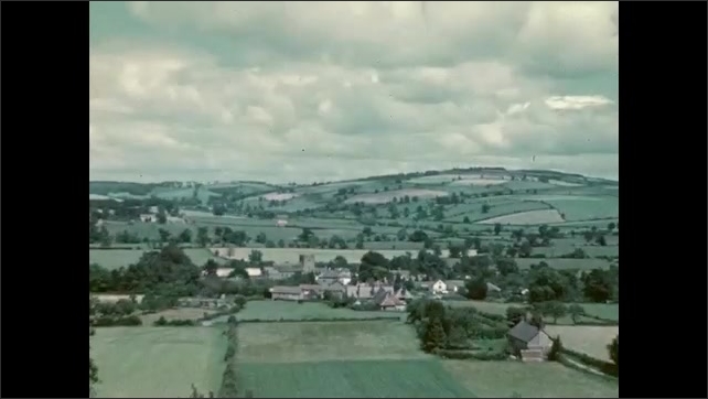 1950s: Long shot, people walking toward camera. Side view, people walking in field. View of fields, village. View of fields. 