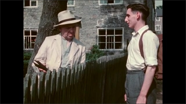 1950s: Clapboard, shots of men talking over fence. Close up of man nodding. Close up of man. 