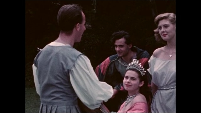 1950s: Shots of people in period costume listening to man play guitar. People in costume, man reciting to group. 