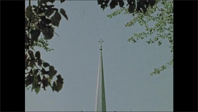1970s: Steeple of church, cross on top. Stained glass windows.