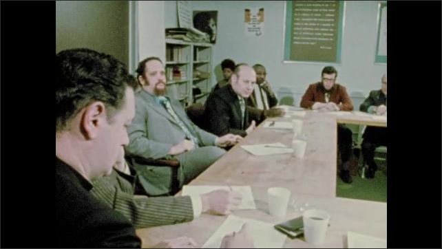 1970s: People around table in meeting, talking. Newspaper headline. Rabbi in meeting, newspaper headline, priest in meeting, people around table talking in meeting. Man gives sermon to women.