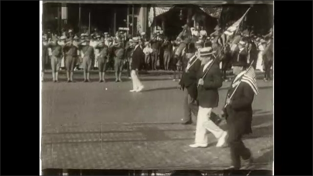 1910s: President Woodrow Wilson sits at desk with papers. People march in parade down road. Courtyard with garden and fountains. Intertitle card.