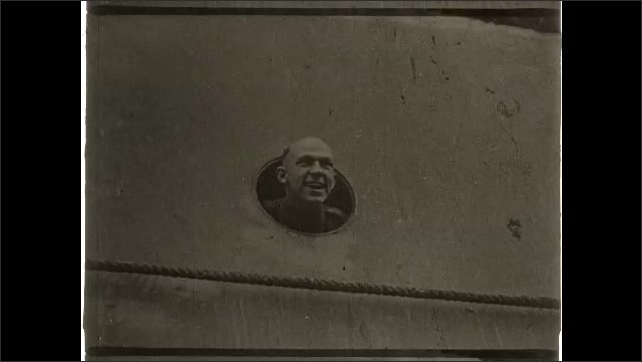 1910s: Woman waves material at soldiers on board docked boat. Intertitle card. Man with head out of porthole on boat, talking. Intertitle card. People saluting on lawn.