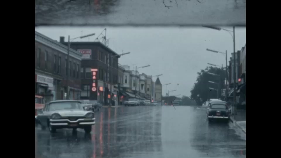 1960s-cars-drive-down-rainy-city-street-archival-footage
