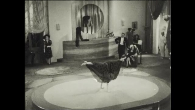 1930s: Woman on floor at performance dances, doing acrobats and contortions.