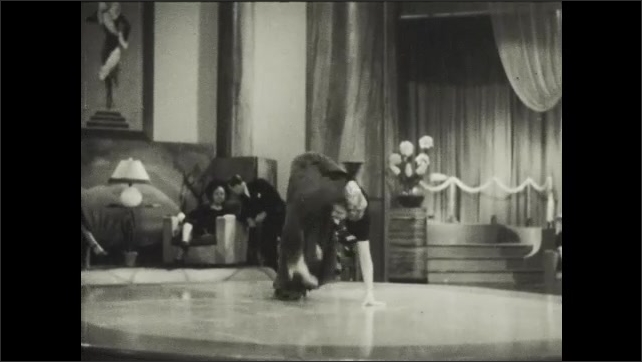 1930s: Woman on floor at performance dances, doing acrobats and contortions.